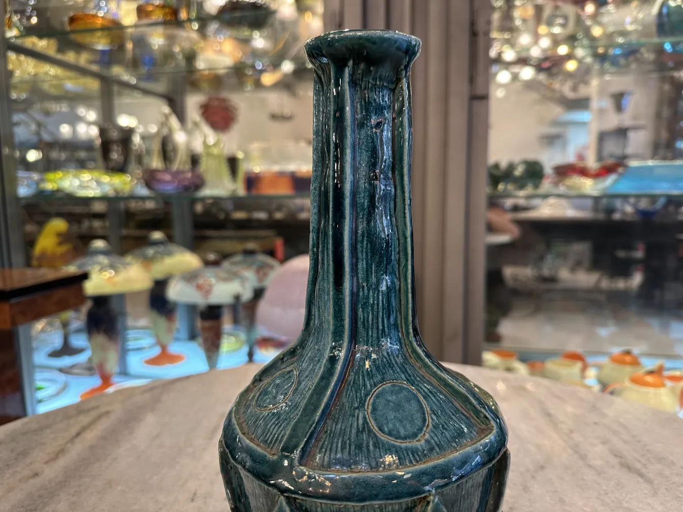 Antique ceramic vase in an antique setting, featuring green tones