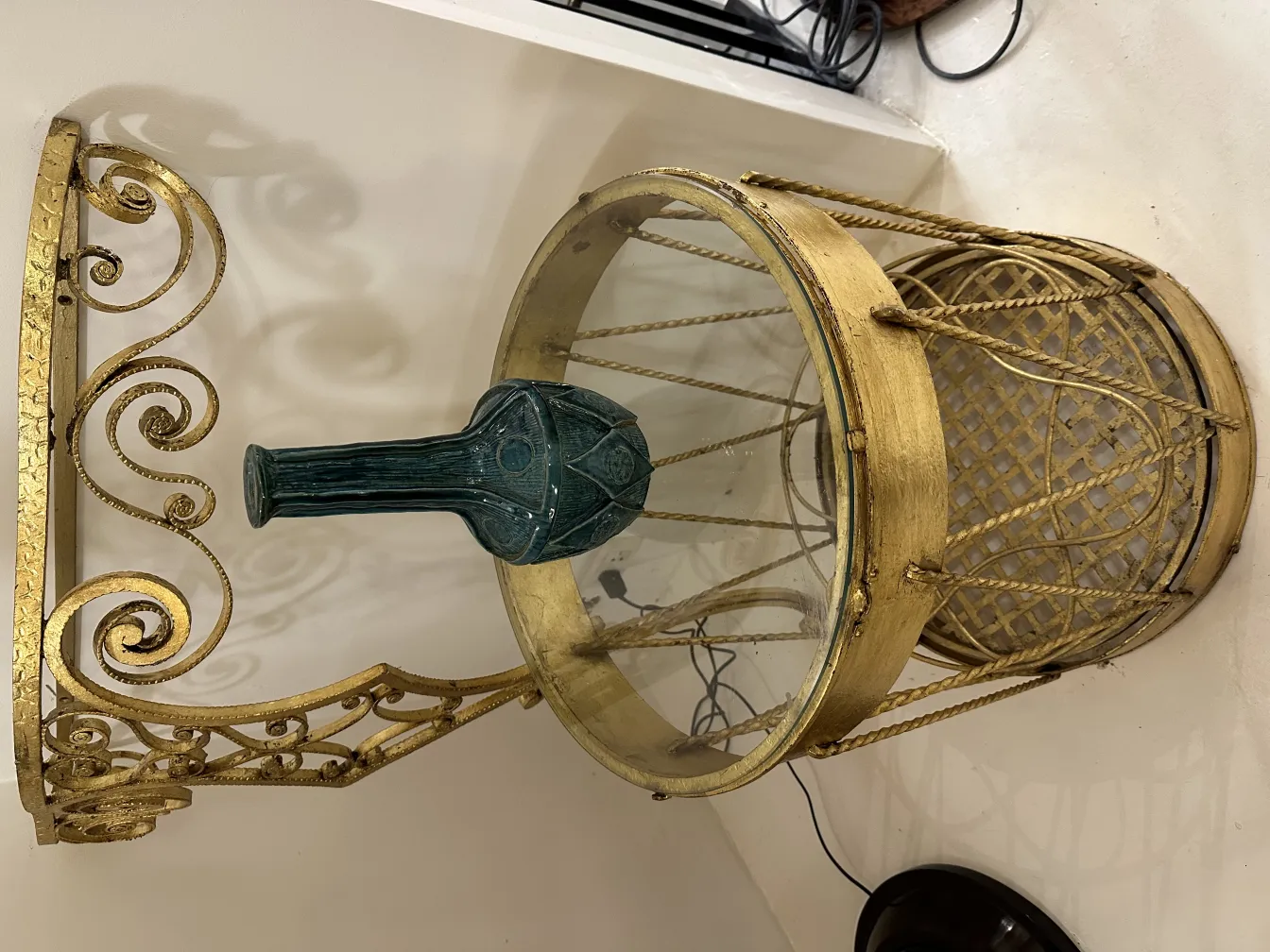 Green ceramic vase on an antique gold table.