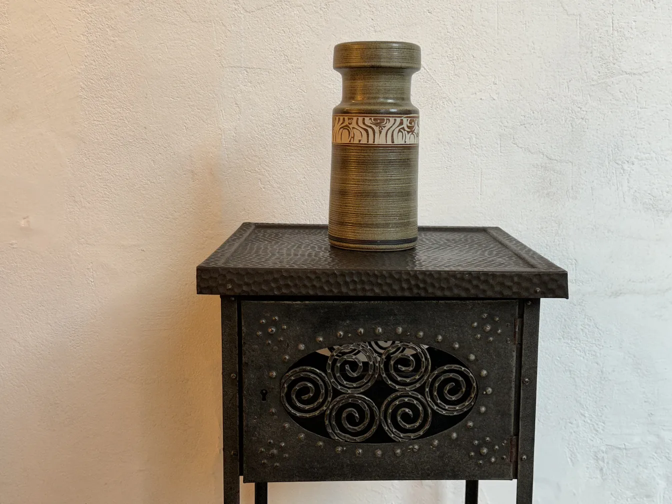 Antique decorative ceramic vase on a metal table.
