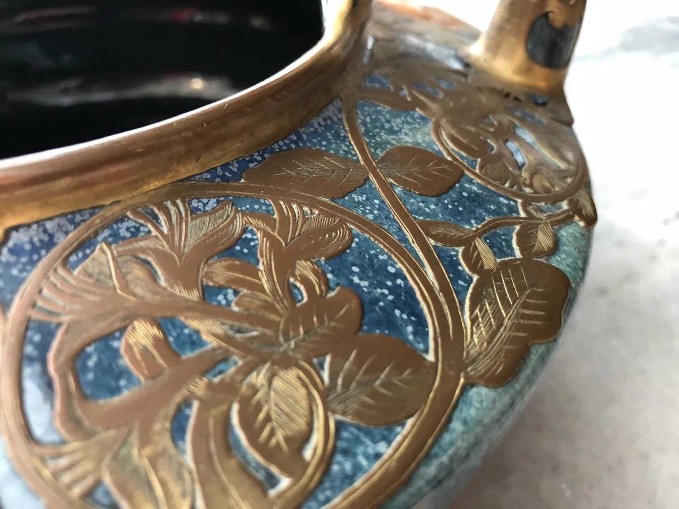 Antique decorative ceramic with golden leaves and blue tones.