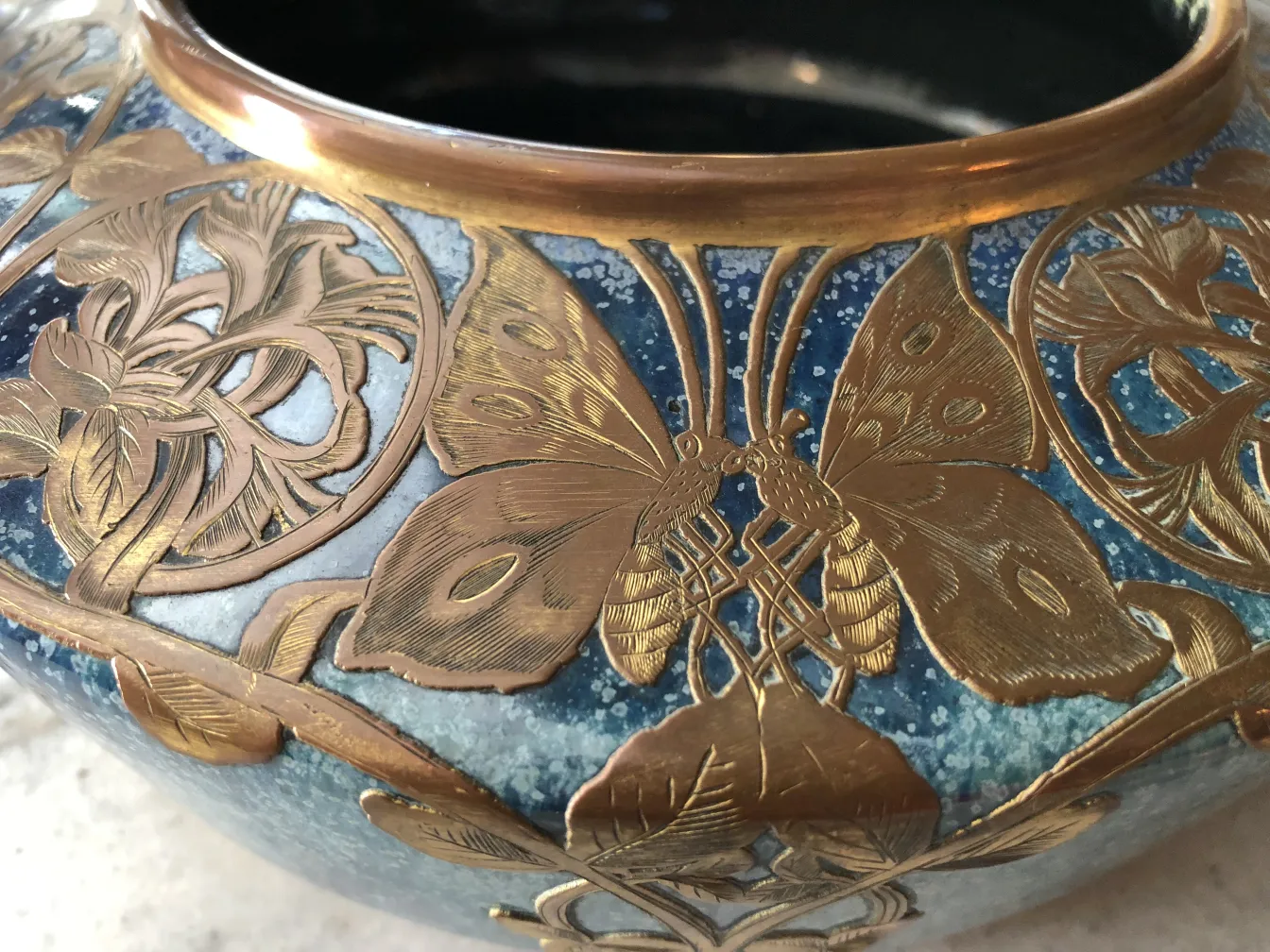 Antique vase with blue color and golden butterfly decorations.