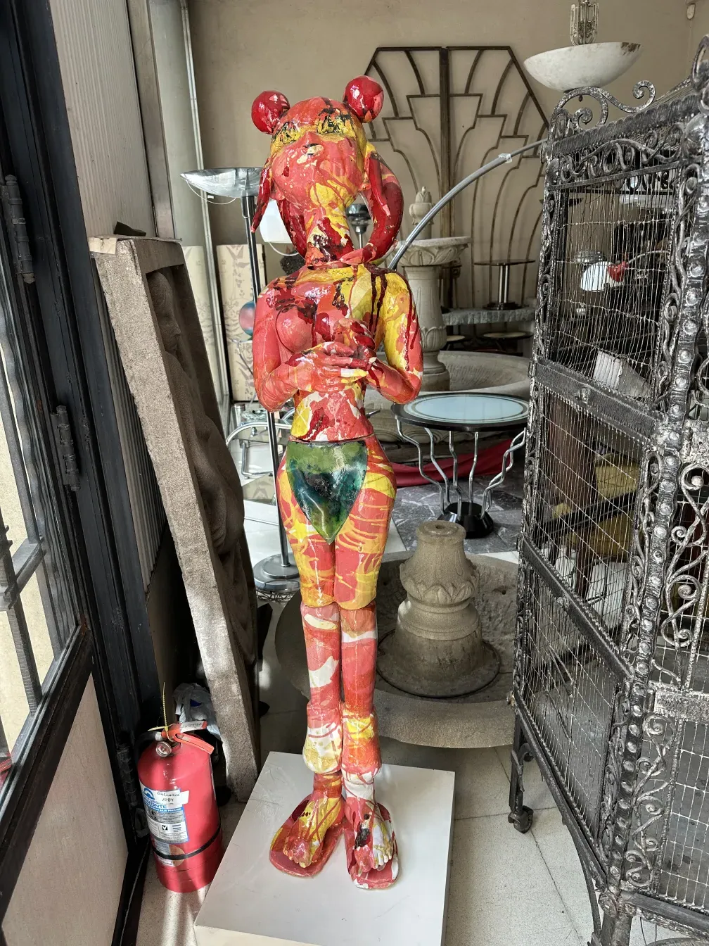 Antique ceramic sculpture in vibrant colors, with decorative background.