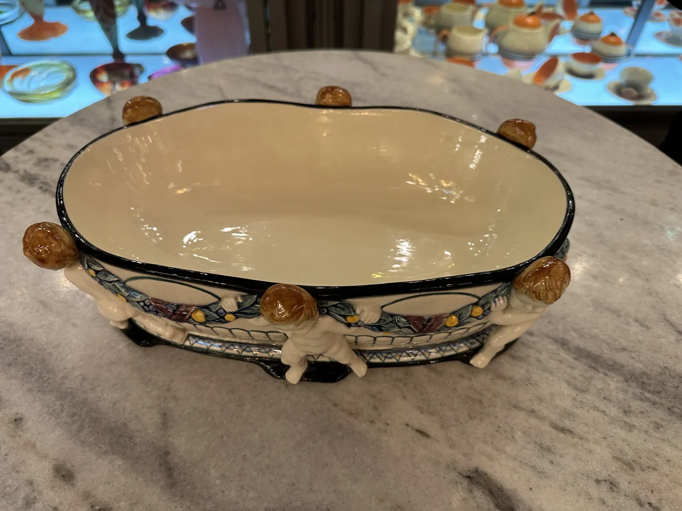 Antique ceramic bowl with figurative details and colorful decor.