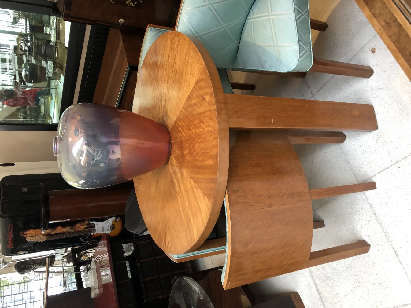 Beautiful antique ceramic with purple and pink hues displayed on a light wood table.