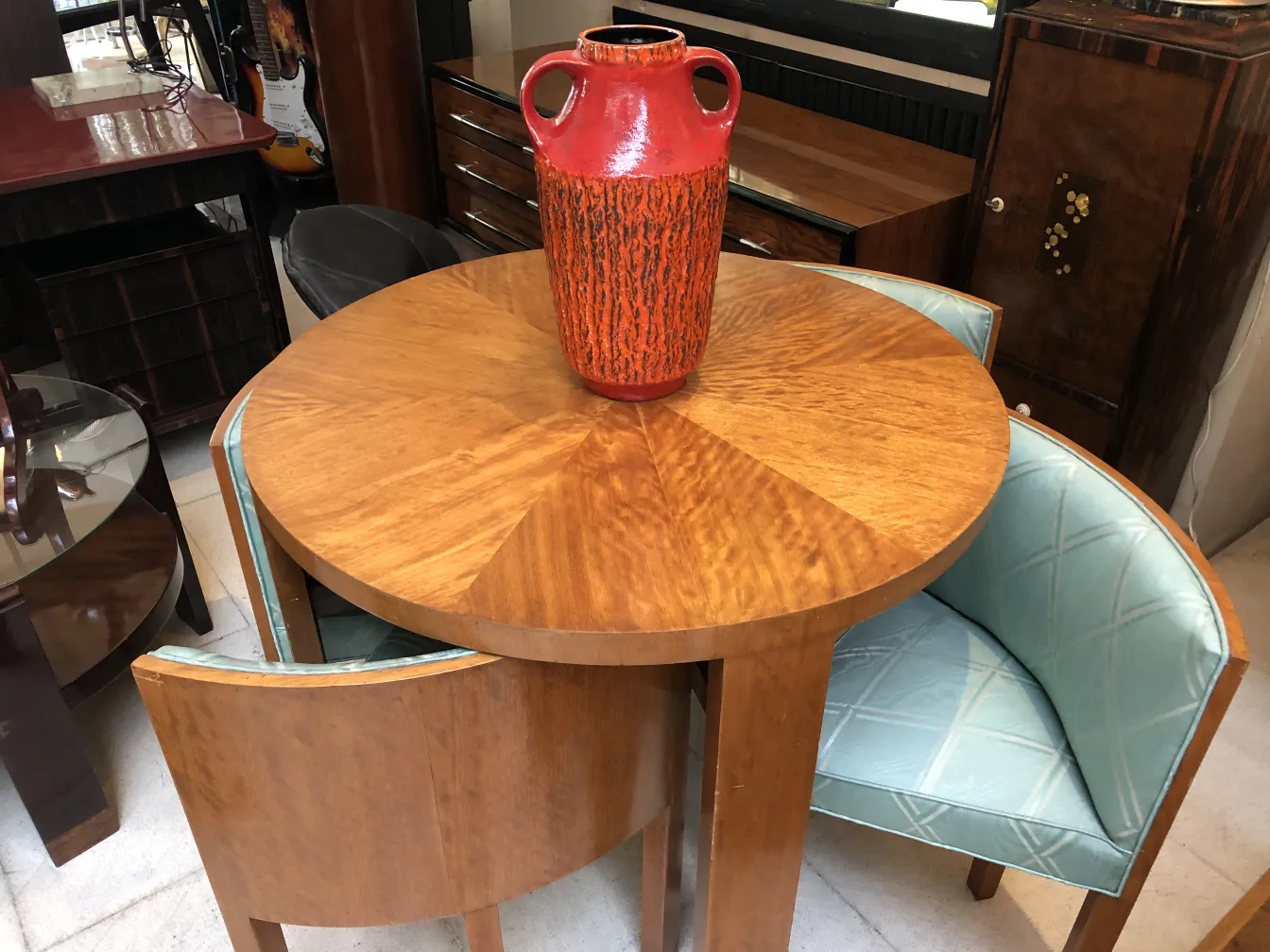 Antique red and orange ceramic vase on a wooden table.