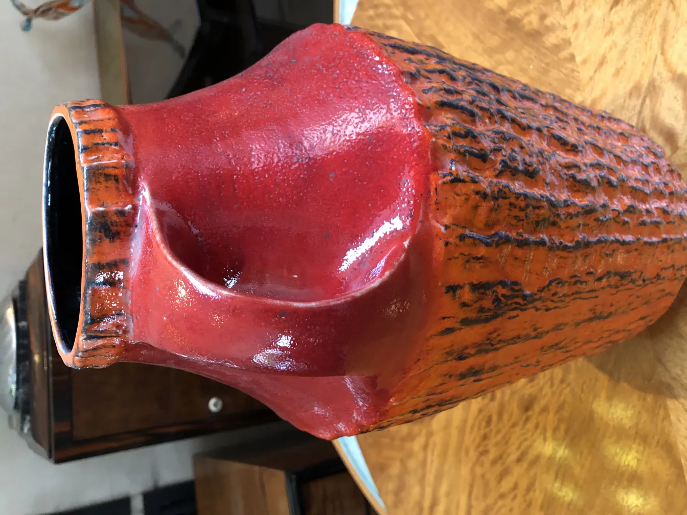 Bright red antique ceramic vase with textured design.