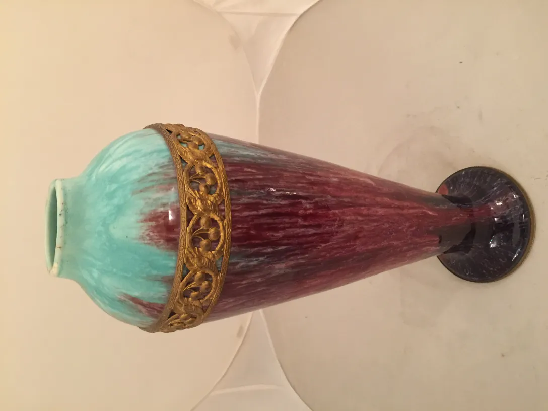 Antique ceramic vase with skillfully designed blue and red colors and a golden ring.