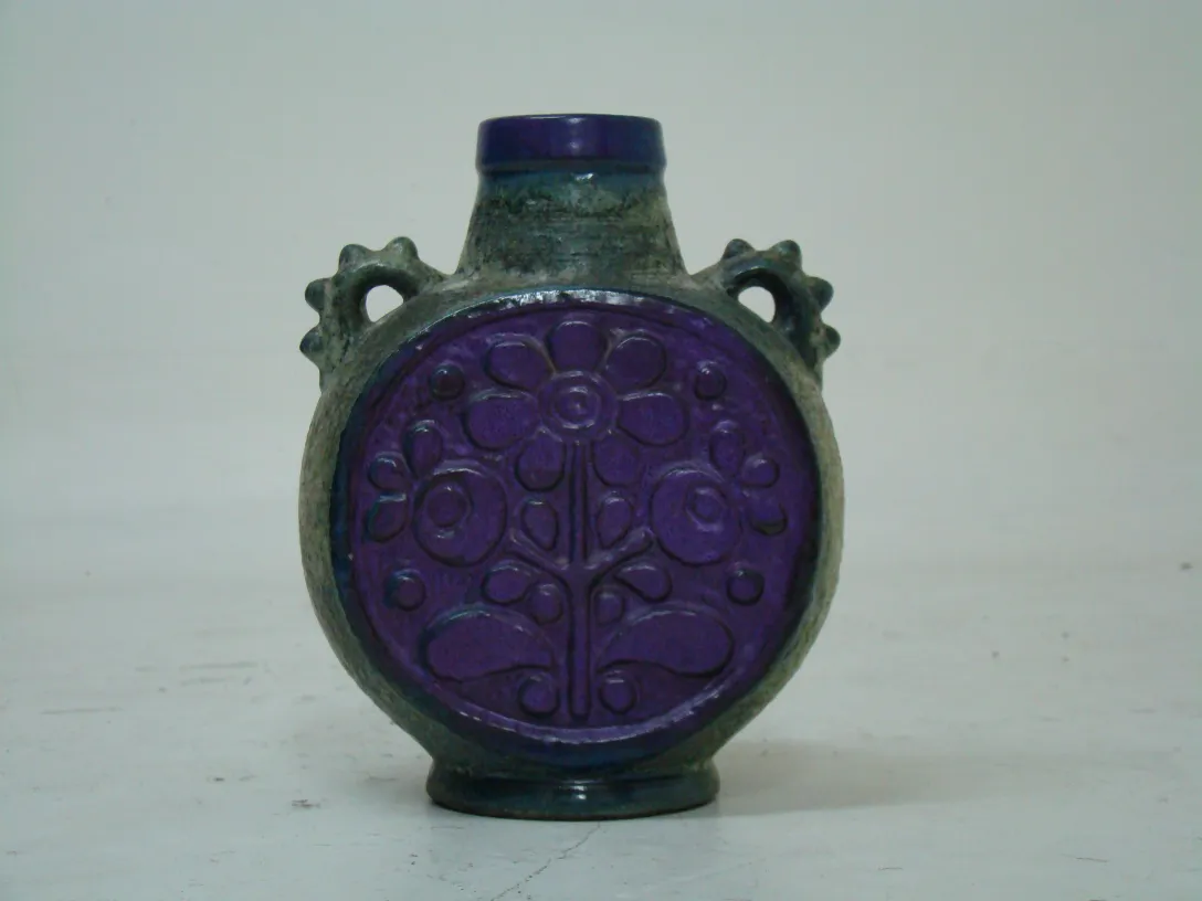 Antique ceramic jug with raised flower patterns, purple color.
