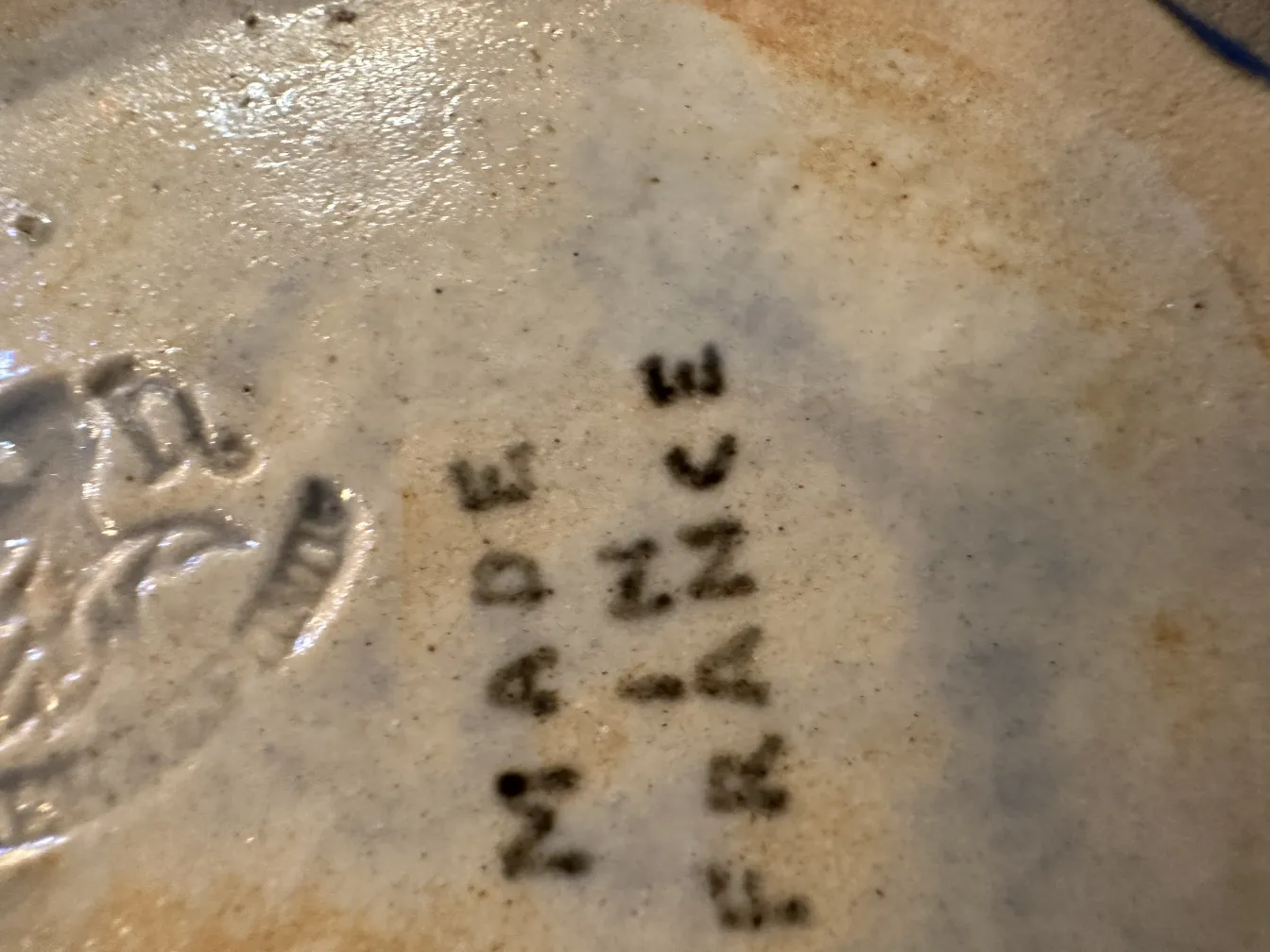 detail of antique decorative ceramic with visible markings, soft hues