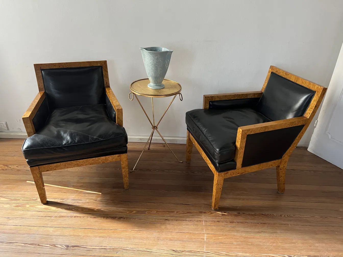 Antique decorative ceramic on a gold table next to armchairs.