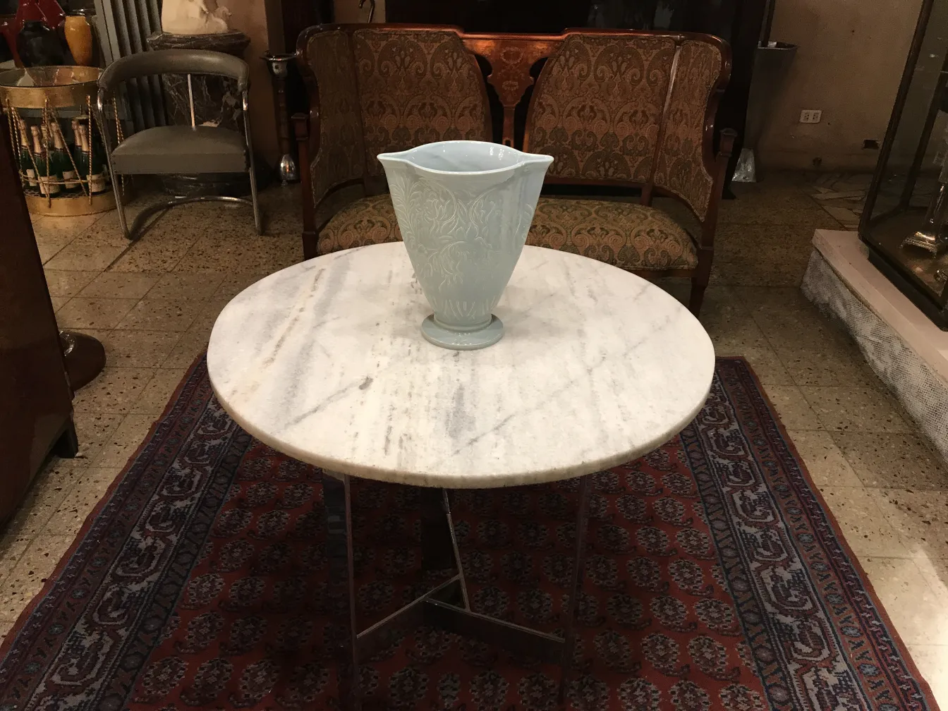 Light-colored antique ceramic vase on a marble table