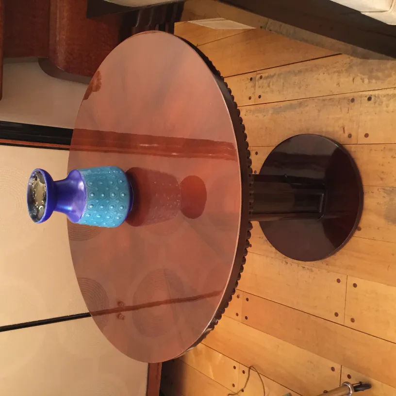 Blue ceramic vase on a round wooden table, elegant setting