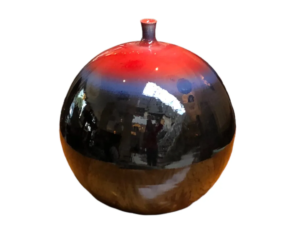 Ancient ceramic sphere with a glossy finish in red and black hues