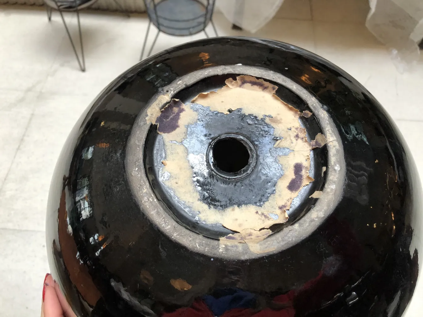 Top view of antique ceramic with black gloss and worn details.