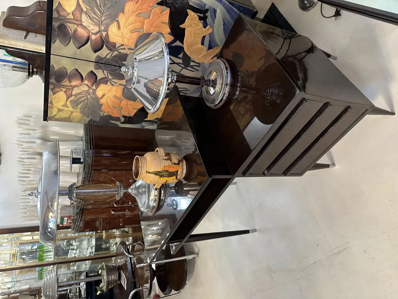 Antique ceramic vase with painted details in an elegant setting. Lanterns and decorative backdrop.