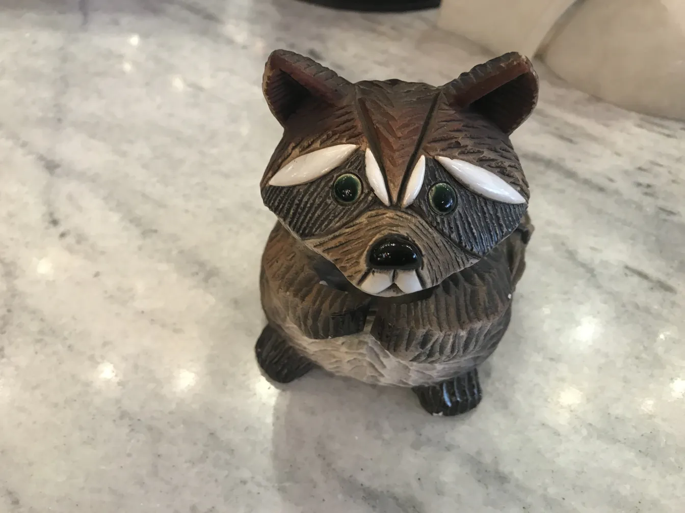 Antique ceramic featuring a cute raccoon with black and white details.