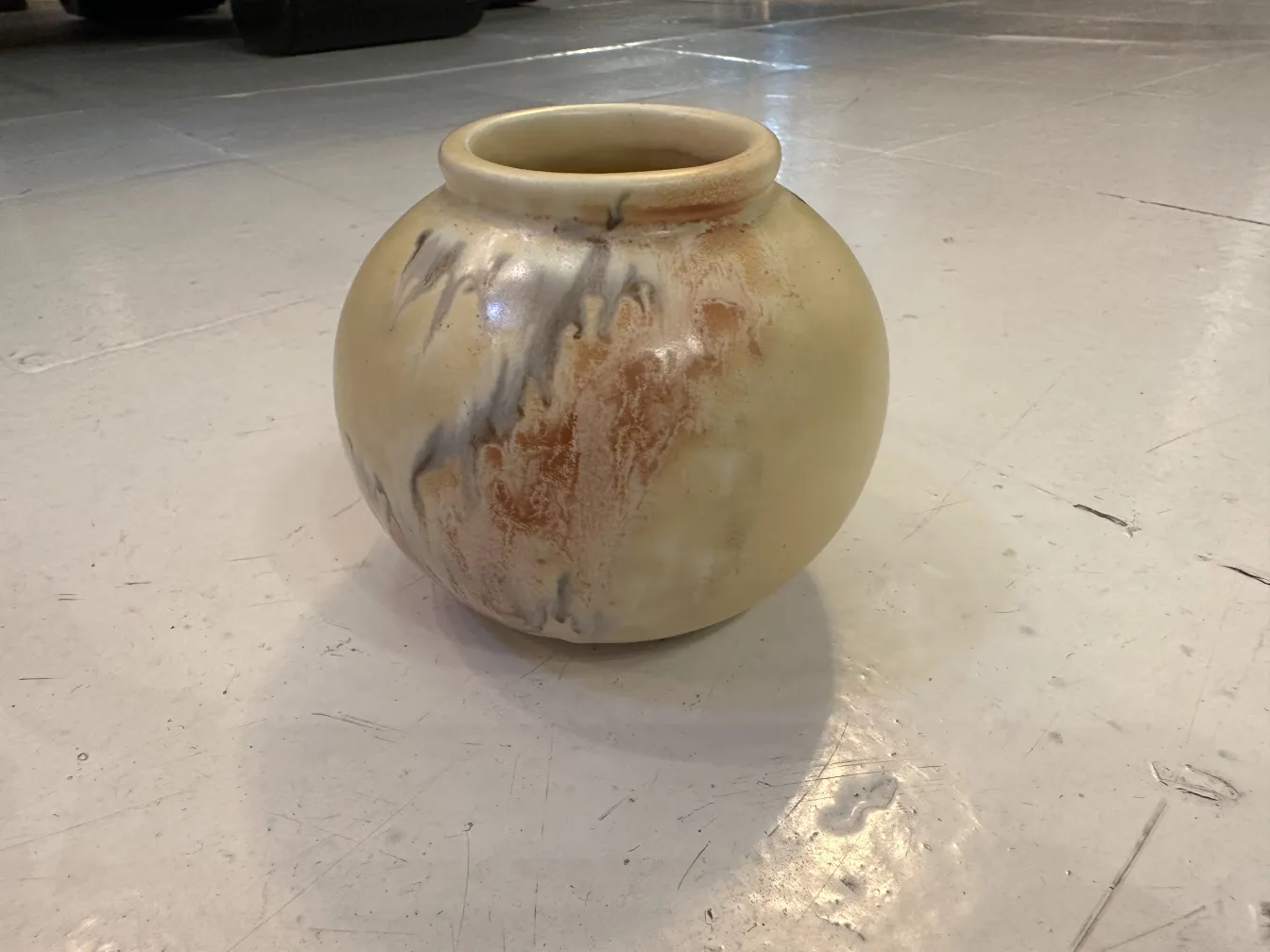 Ceramic vase with beige tones and subtle details, highlighted lights and shadows.