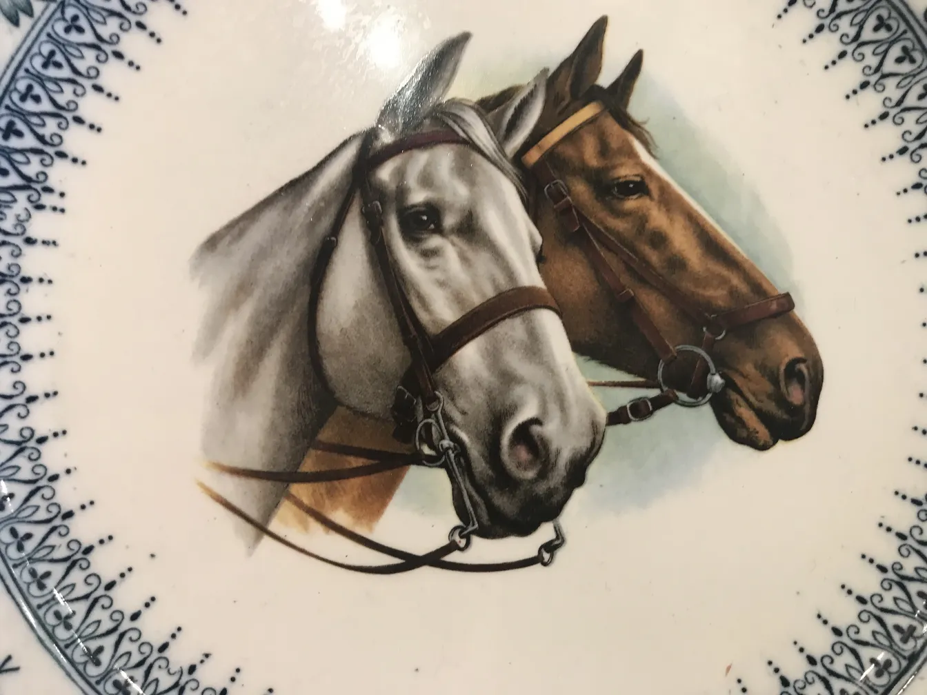 Antique ceramic plate featuring two horses