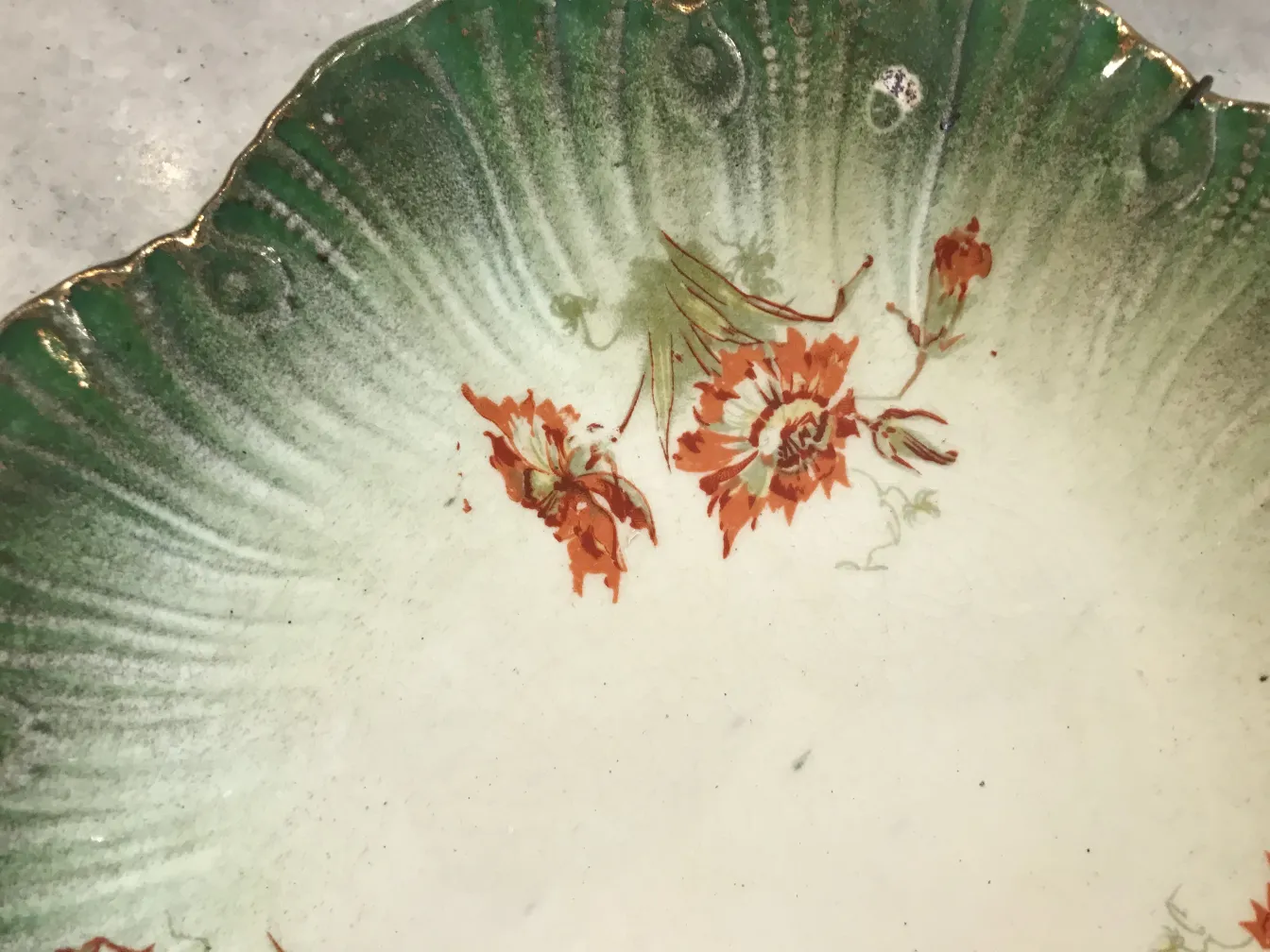 Antique ceramic plate with floral details in green and orange