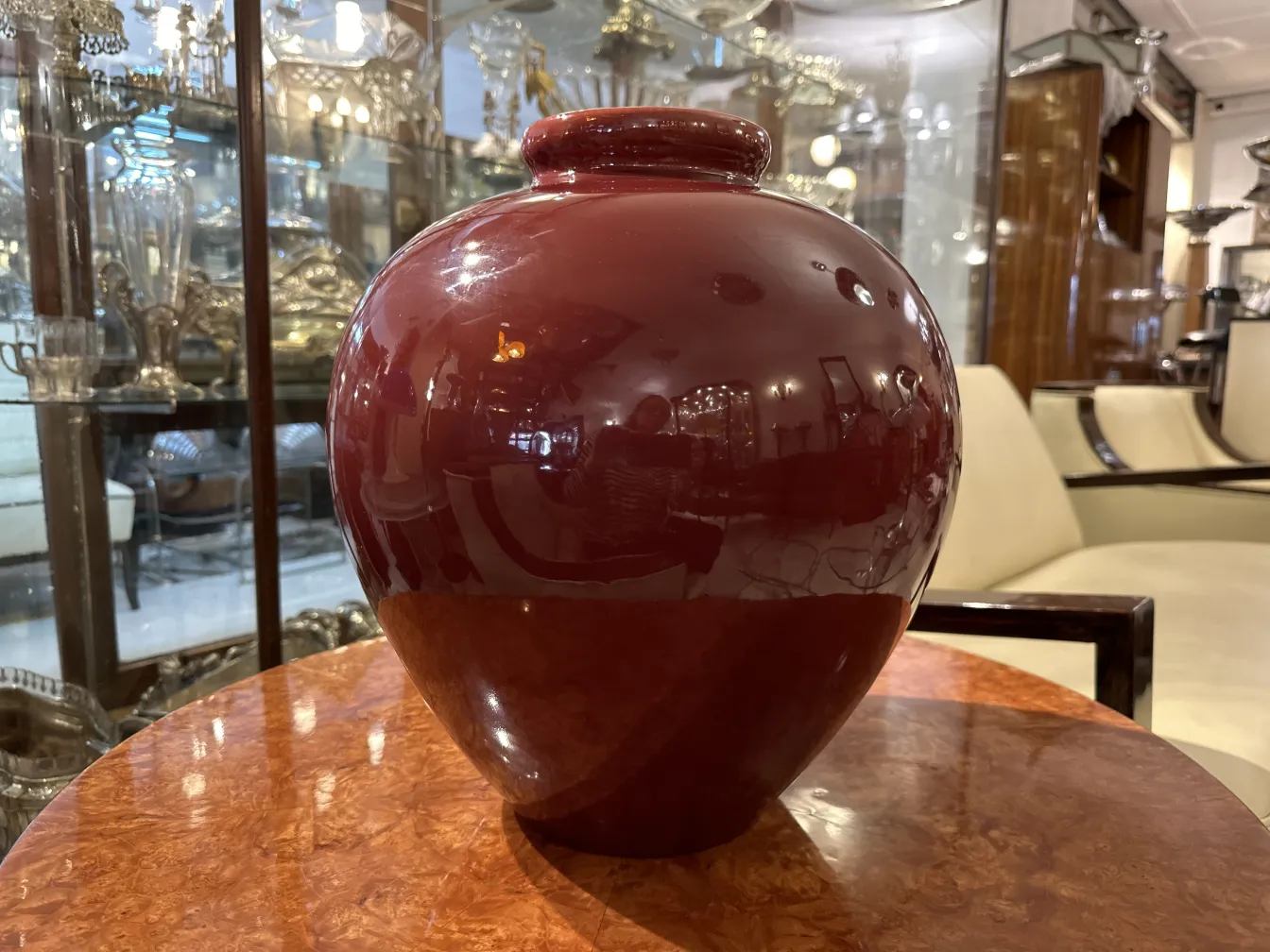 Antique smooth red ceramic vase on a table.
