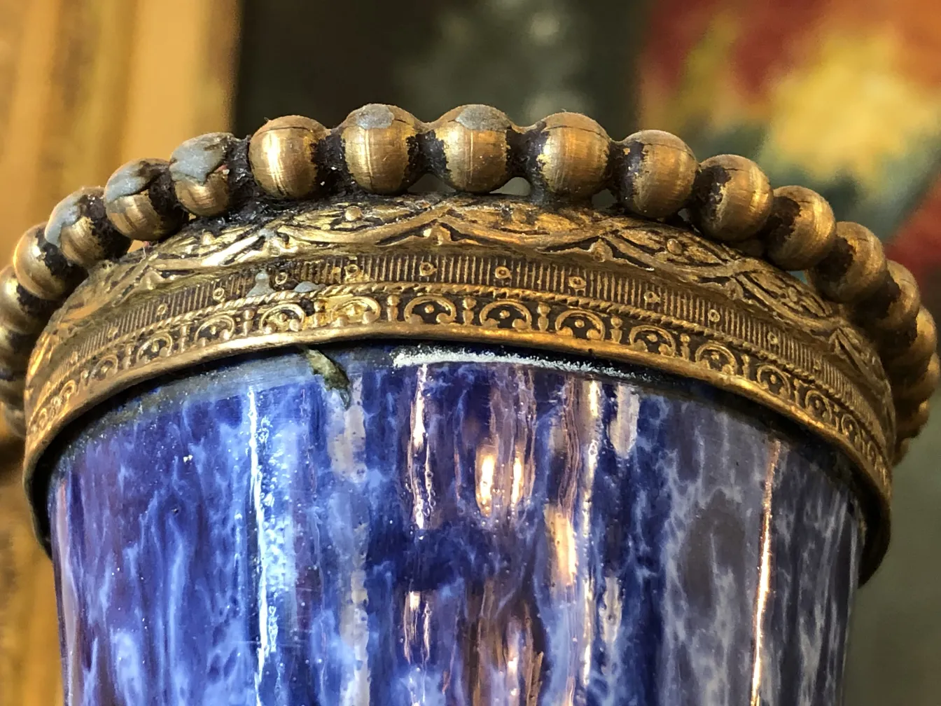 Antique ceramic cup with blue and gold design, ornamental details.