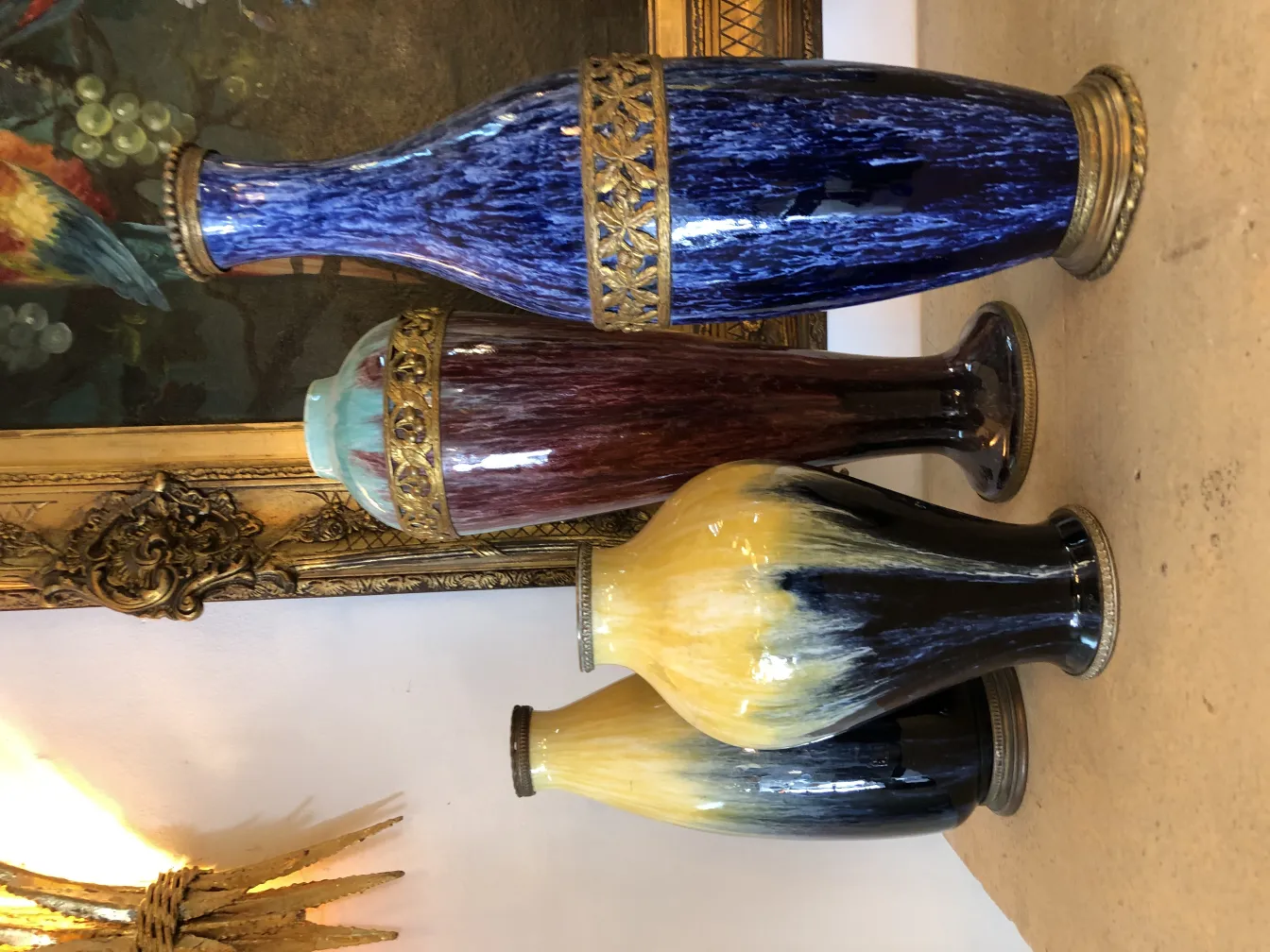 Three antique ceramic vases in blue, red, and yellow with gold details