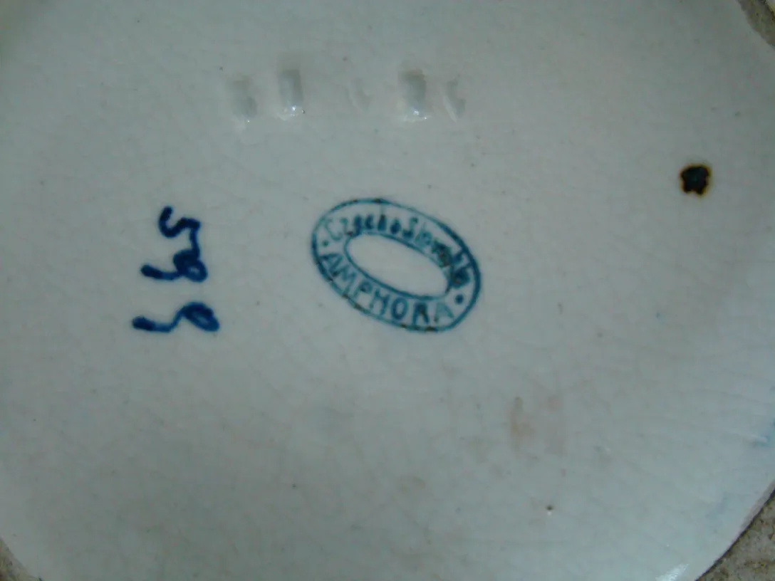 Antique ceramic plate with visible markings and blue details.