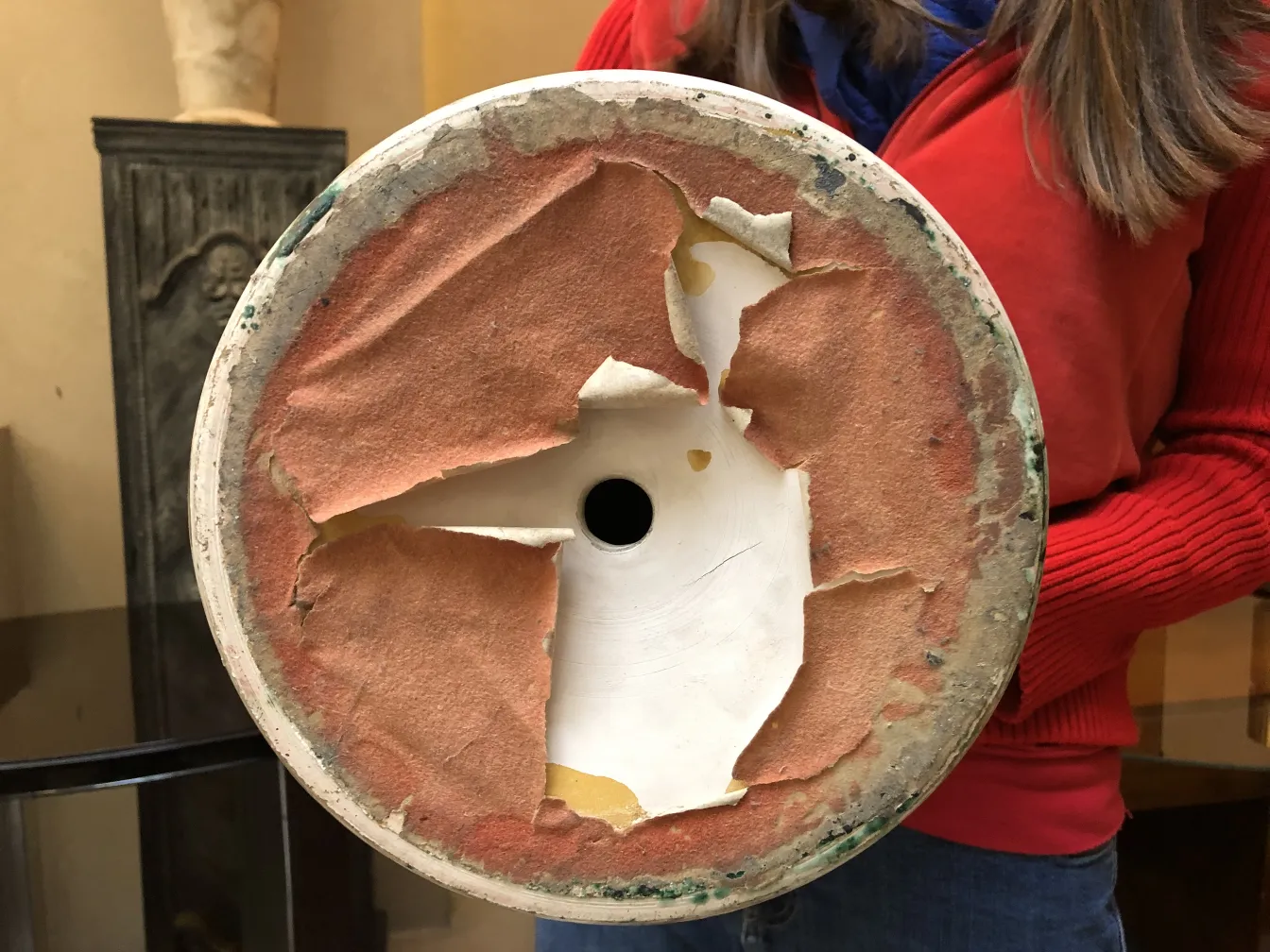 View of the bottom of an antique ceramic with worn texture.