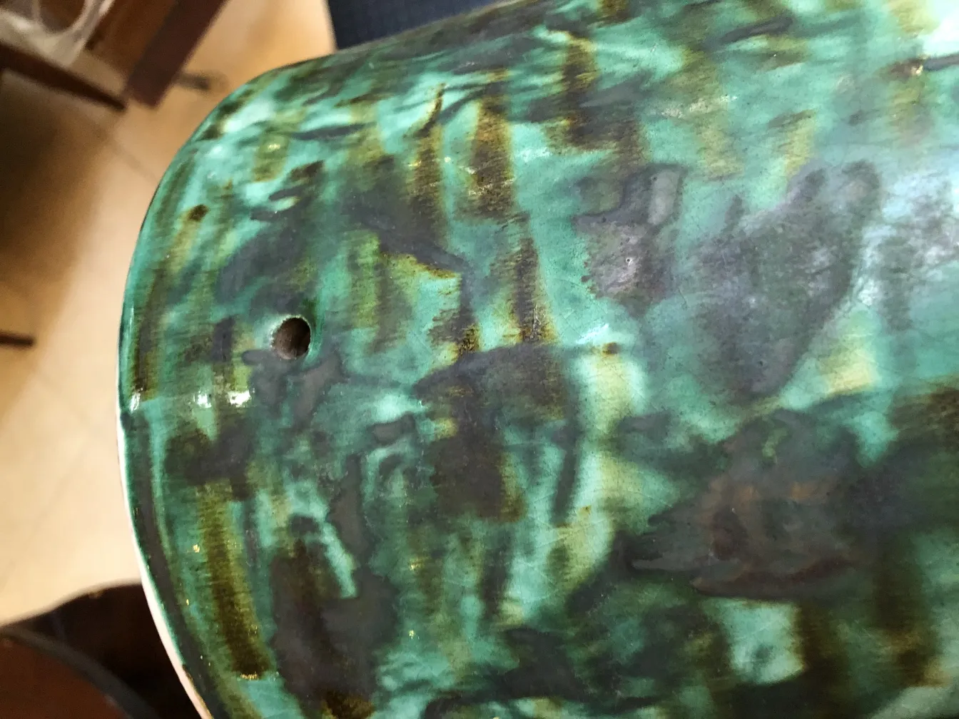 Antique ceramic featuring green tones and dark details