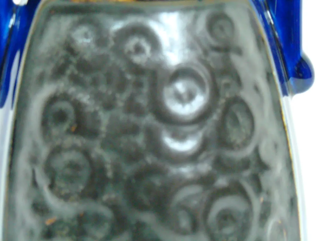 antique ceramic with texture and circular shapes, dark background