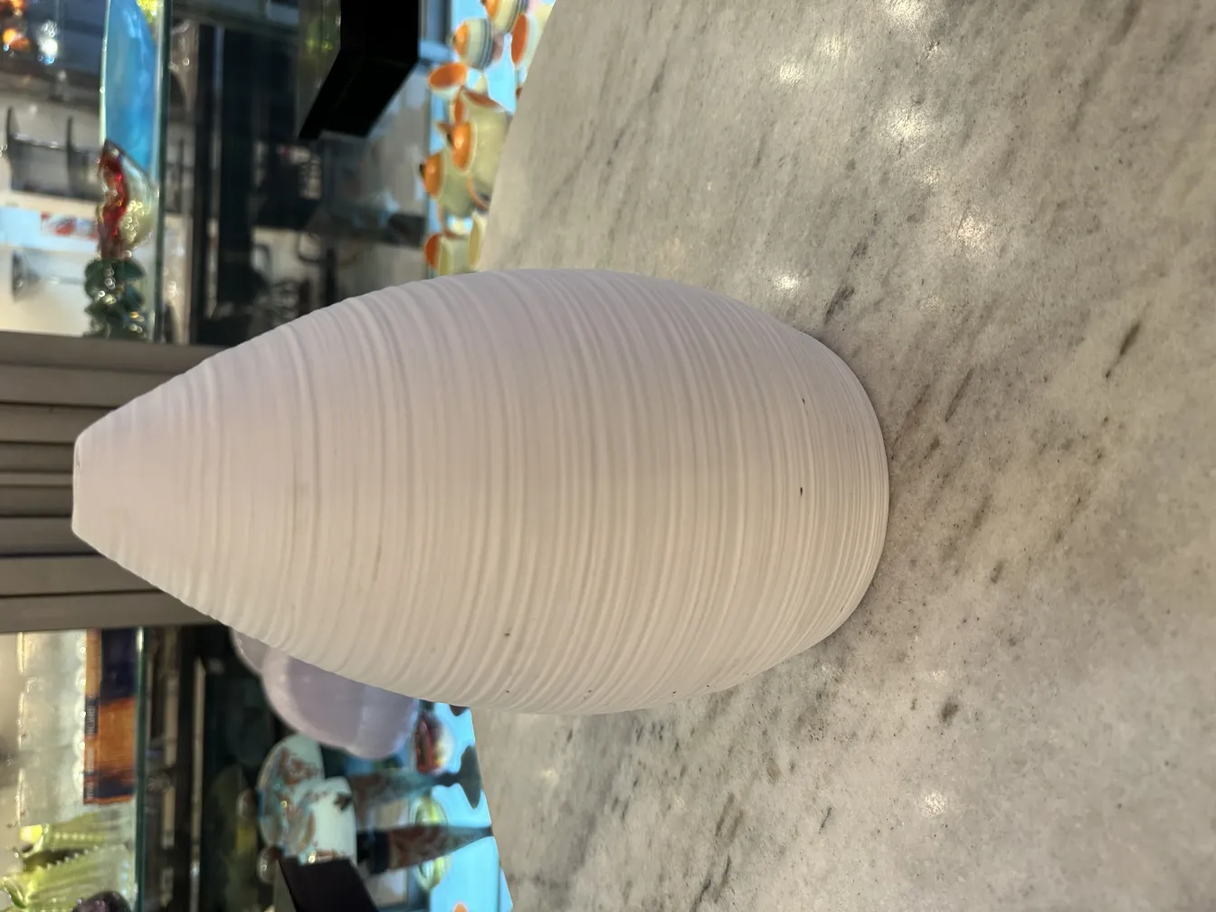 Antique ceramic vase with smooth design and organic shapes, white surface, in an elegant setting.