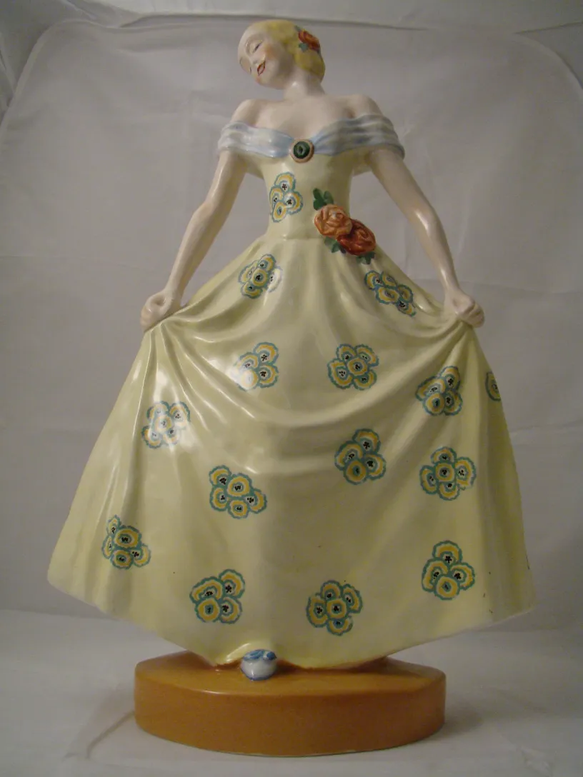 Antique ceramic figure with yellow dress and flowers
