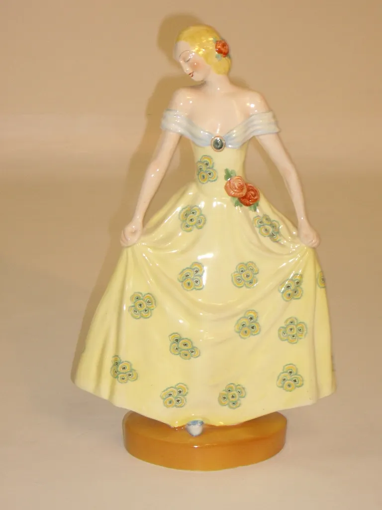 antique ceramic figurine with yellow dress and flowers