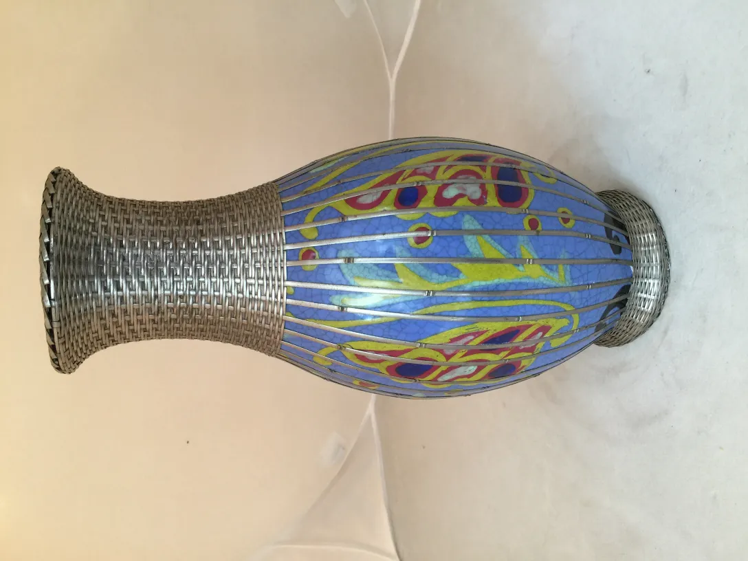 Antique ceramic vase, colorful with floral design, neutral setting.