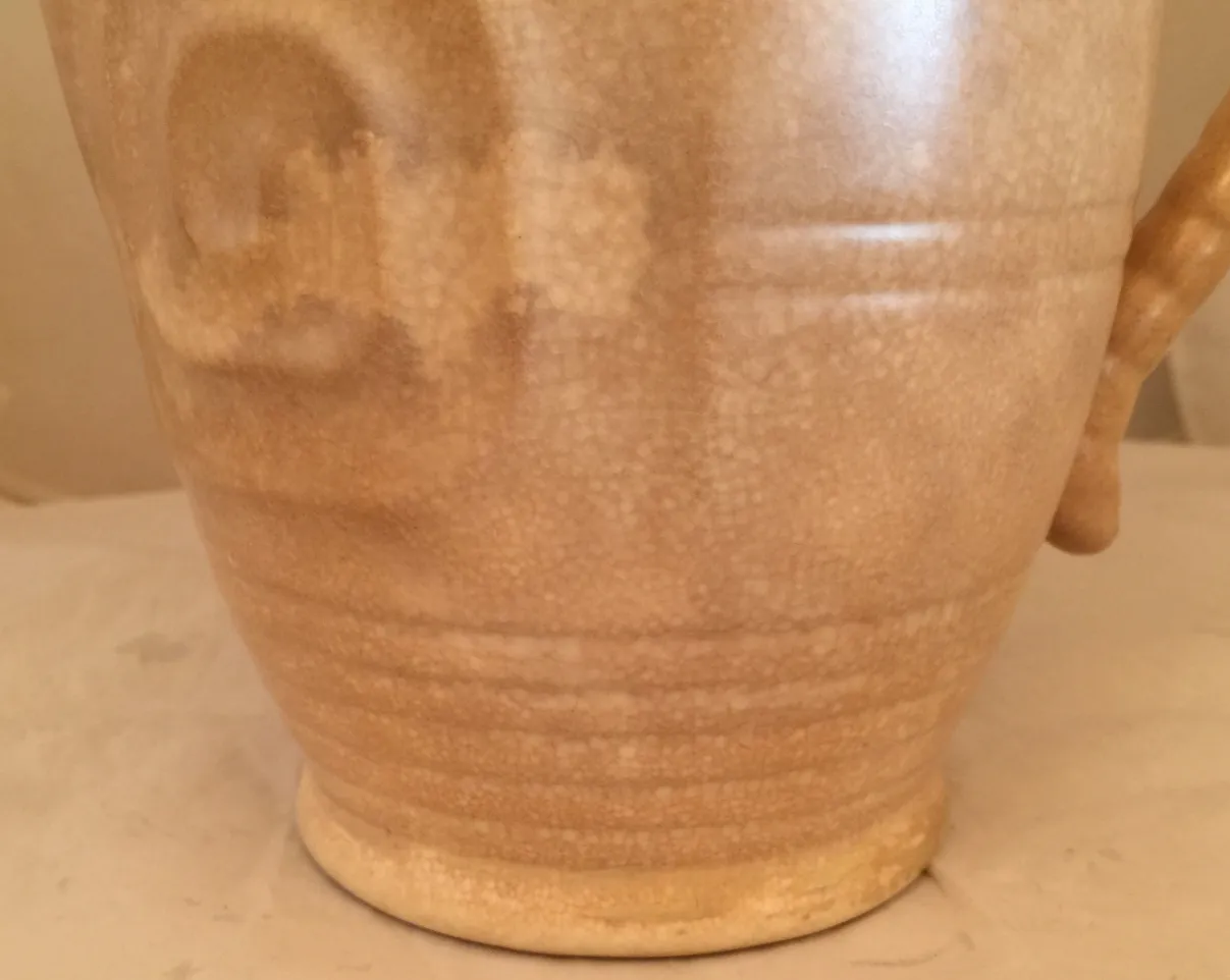 Antique ceramic jug with smooth texture and beige tone, warm ambiance.