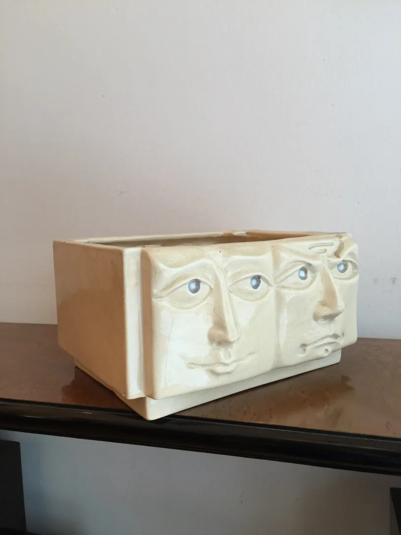 Antique ceramic with three face design in light tones.