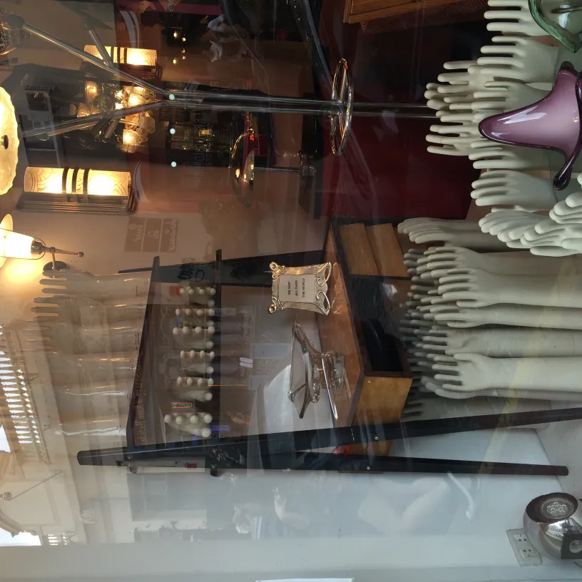 Display of antique ceramics in a shop window with decor.