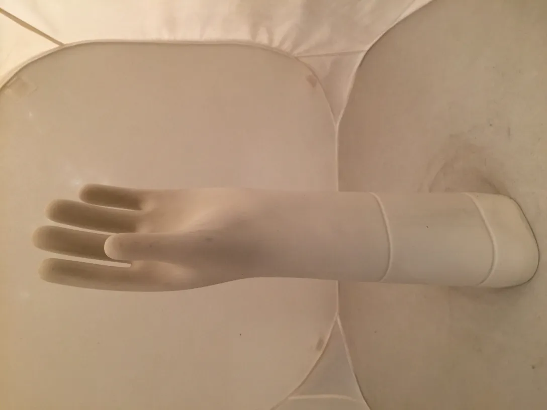 Antique white ceramic hand against a light background.