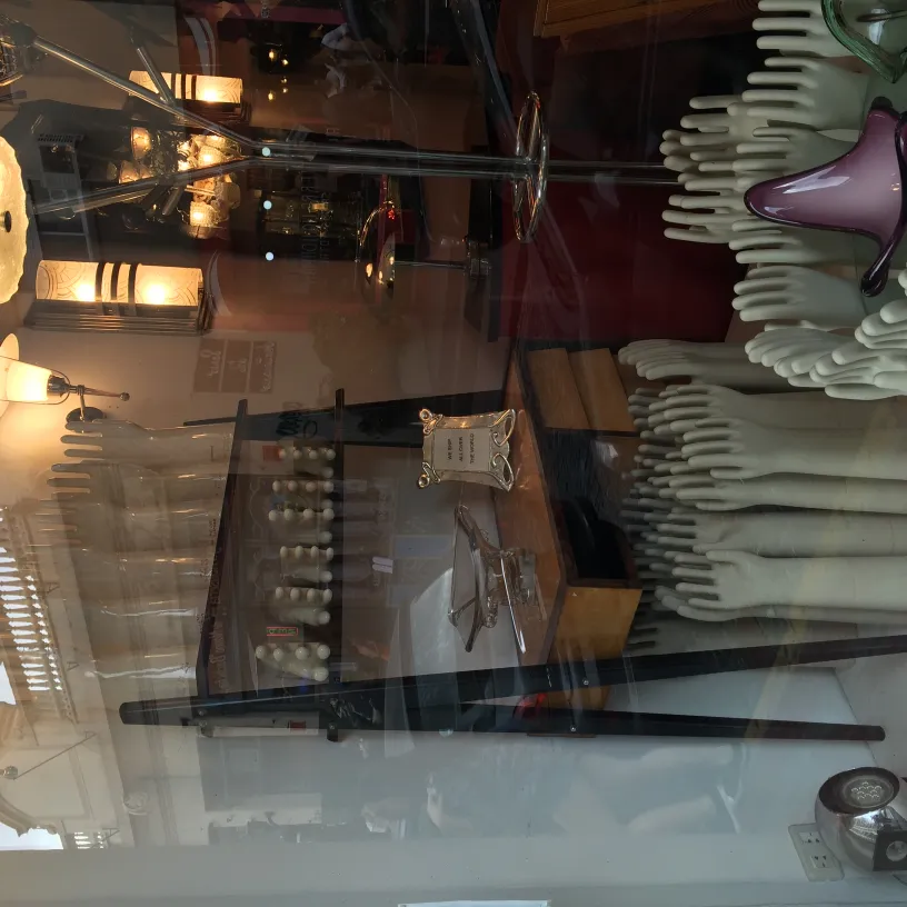 Antique decorative ceramic displayed with various items in a showcase.