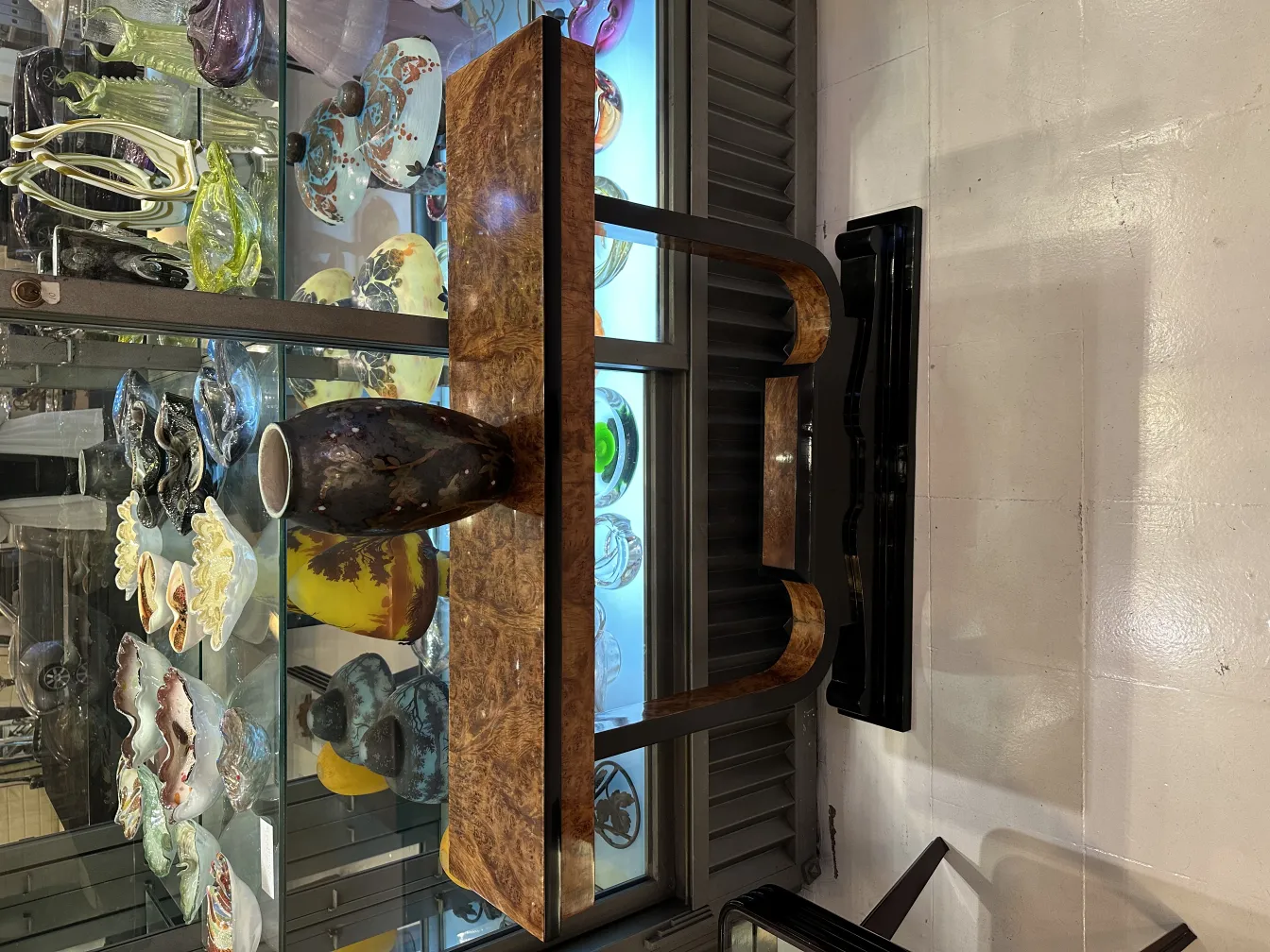 Antique ceramic vase on a decorative table, surrounded by other items.