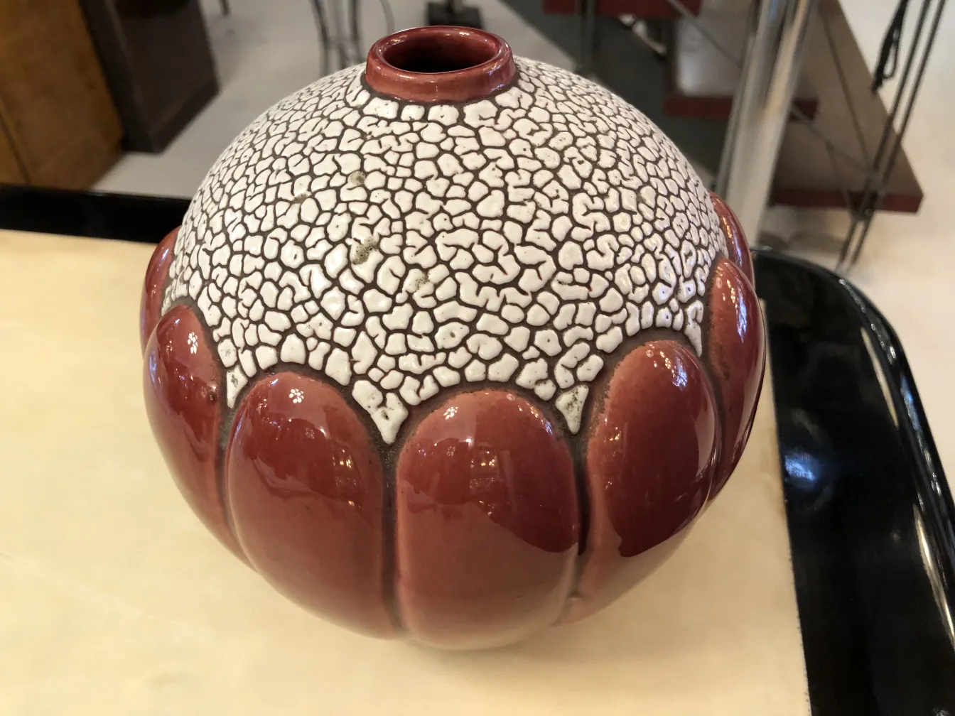 Antique decorative ceramic vase with red and white design.