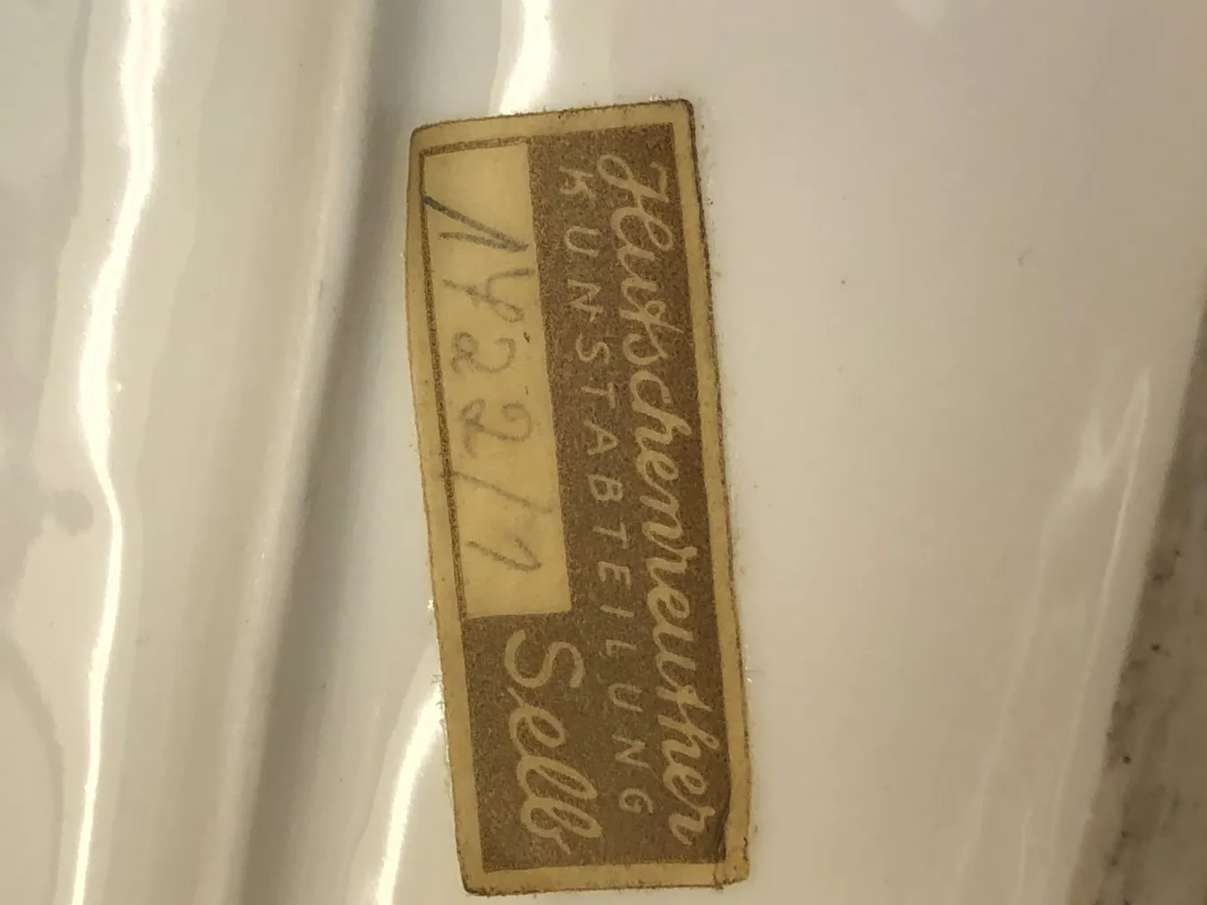 Antique white ceramic with visible descriptive label.