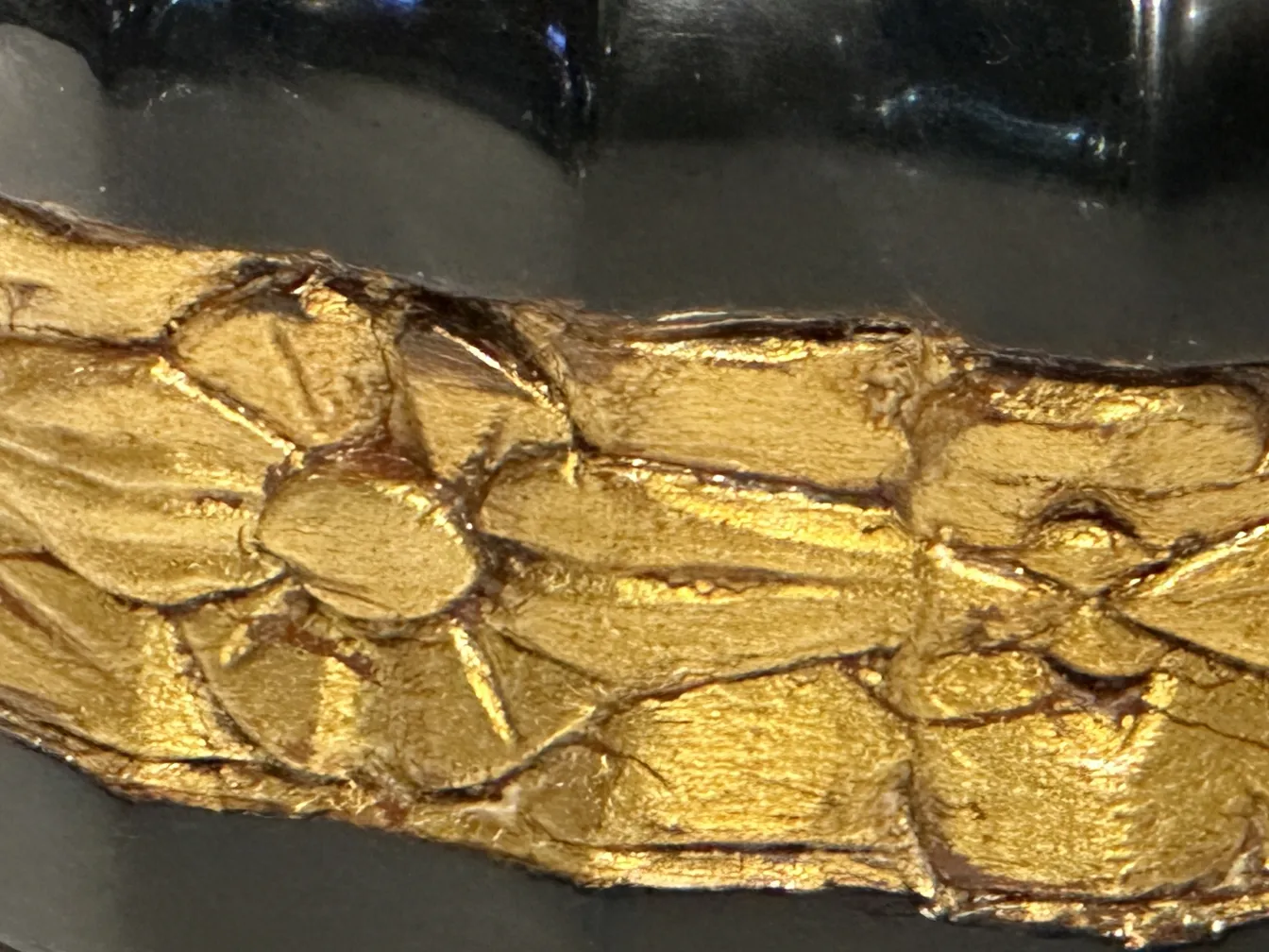 Golden details on an antique cabinet, highlighted against a dark background.