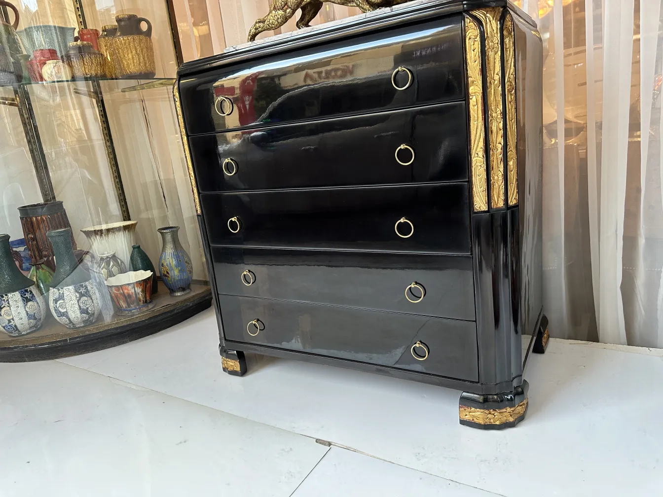 Antique black cabinet with gold accents, classic style on display.