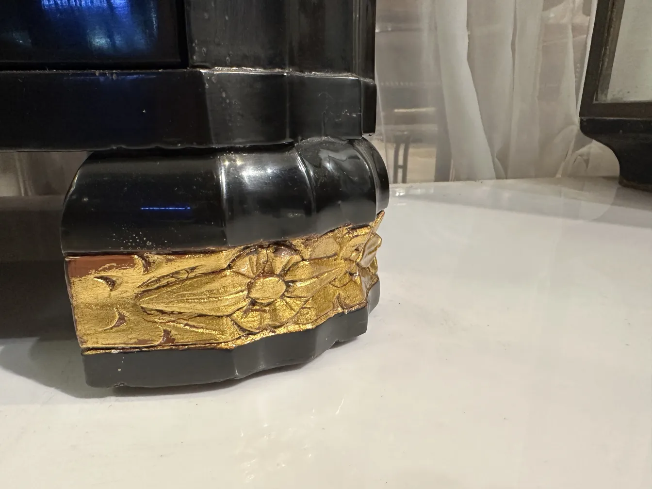 Corner of an antique cabinet with golden details on the base.