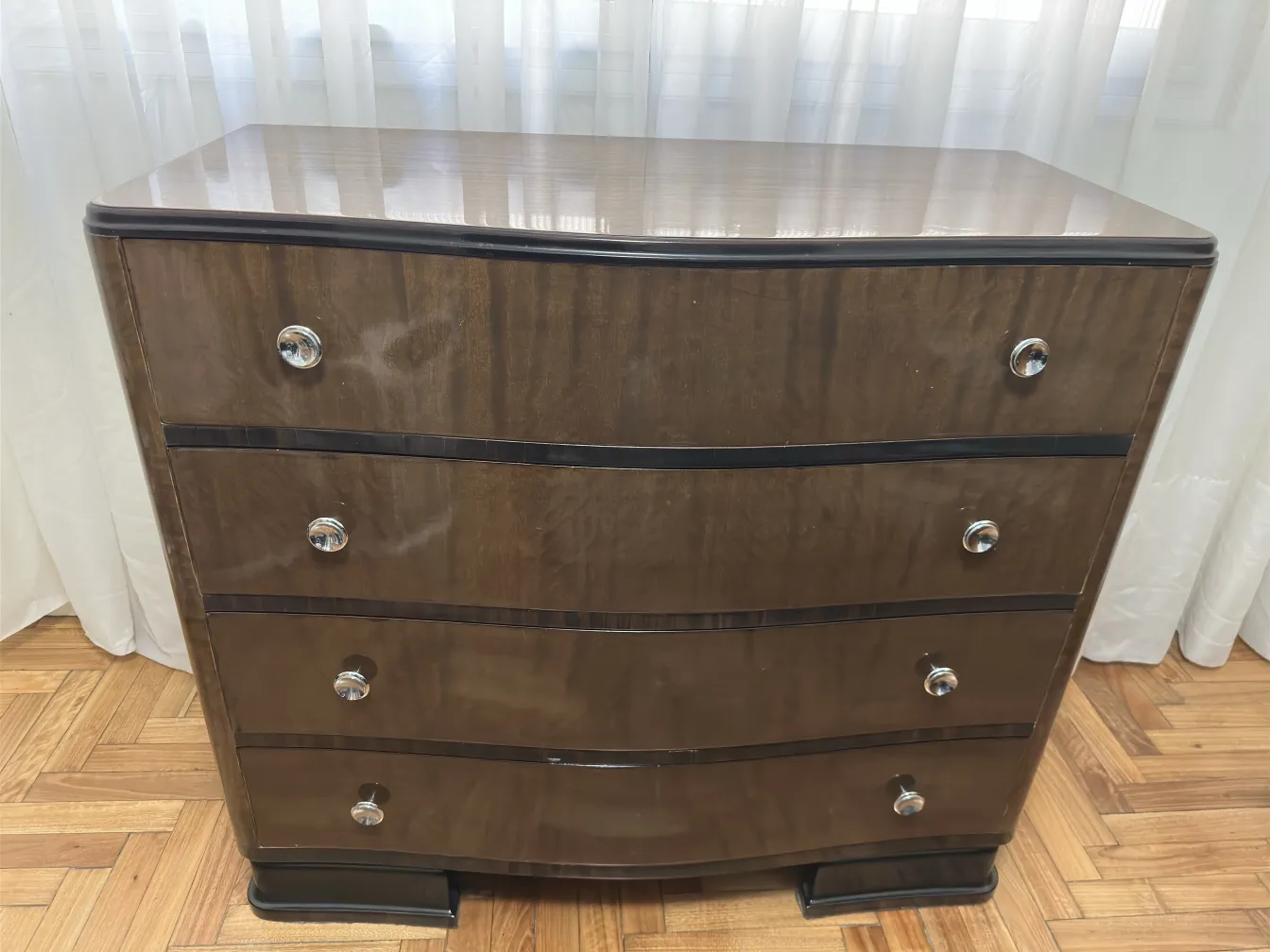 Antique cabinet with four drawers in a bright setting.