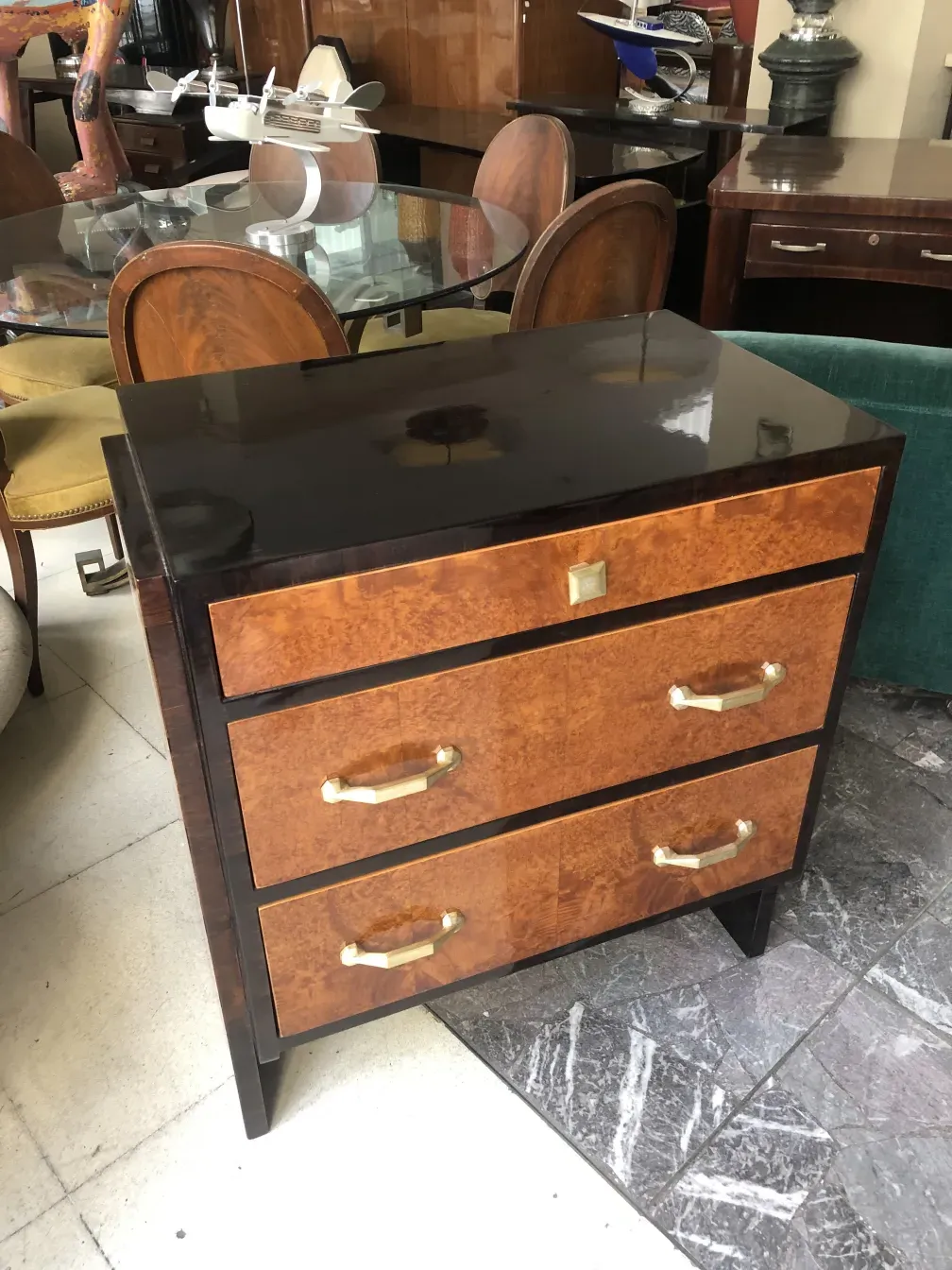 Antique cabinet with wooden finishes and golden handles in a classic setting.