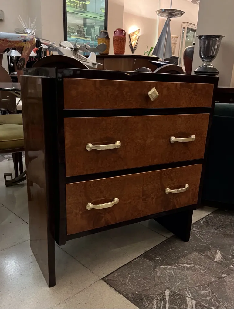 Antique cabinet with two drawers and gold handles in a stylish setting.