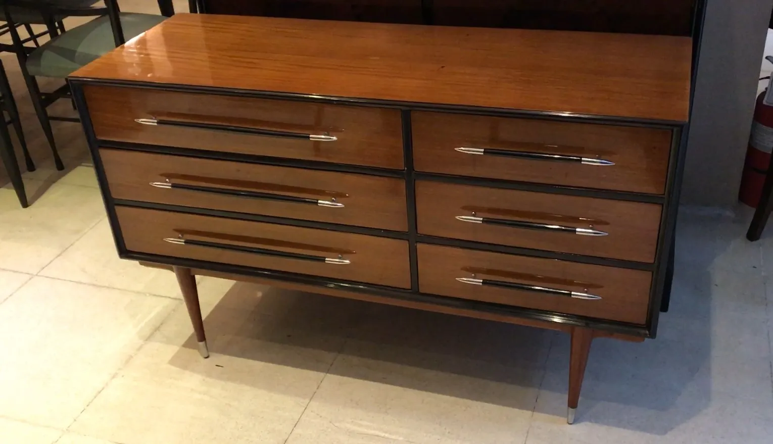 Antique cabinet with six drawers and metal handles, against a light background