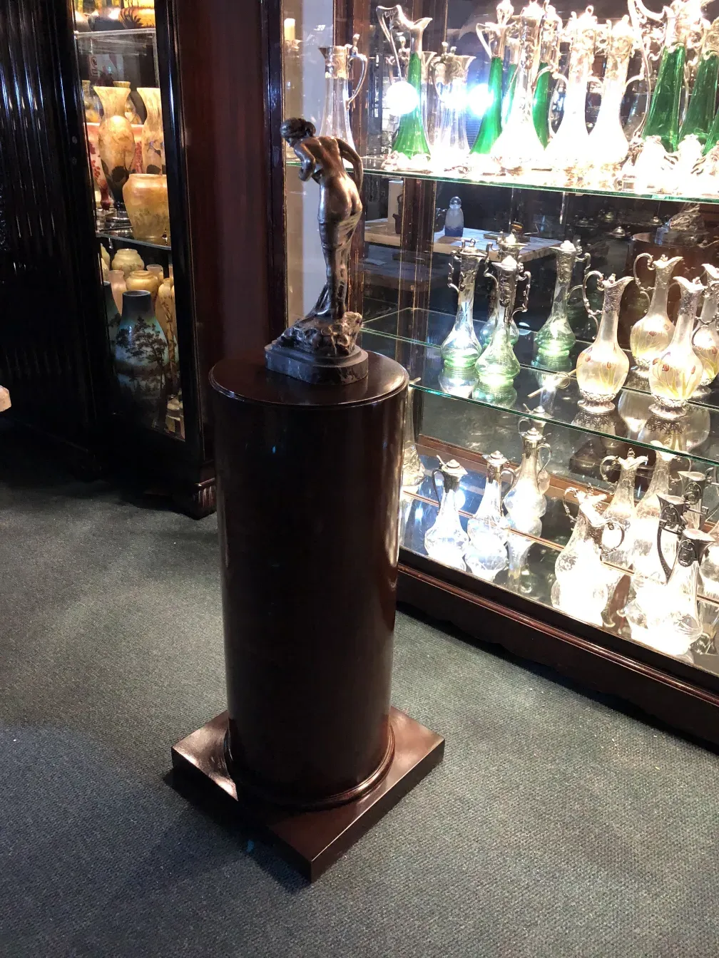 Antique decorative column featuring a sculpture in an elegant setting